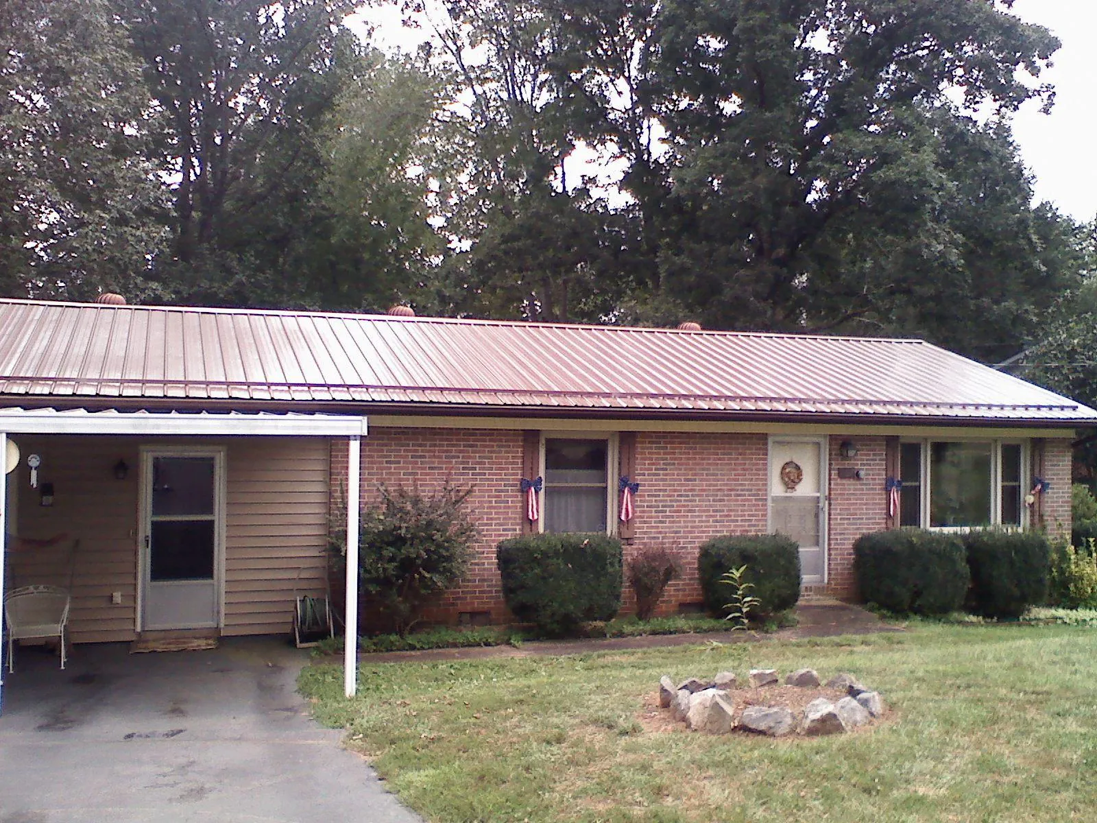 Bronze metal roof and carport on a brick ranch home — Roof Repair work by our crew in Soda Springs